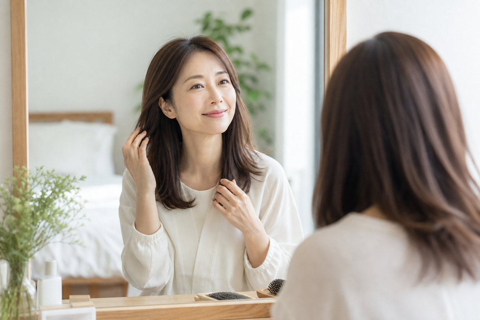 朝の鏡の前で髪を整える女性